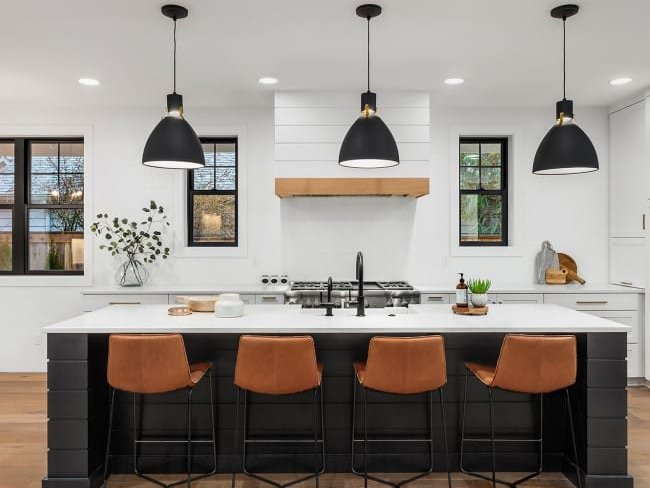 gray kitchen island with white countertop and brown chair on a brown floor by John's Flooring in Union, MO